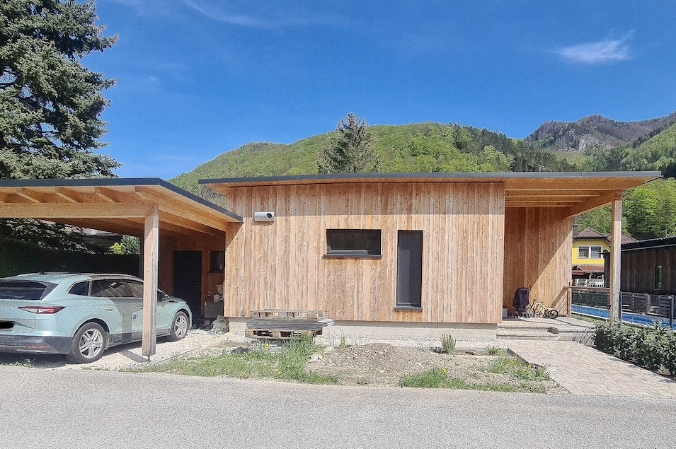 Carport und Eingangsbereich zum Einfamilienhaus mit Holzfassade